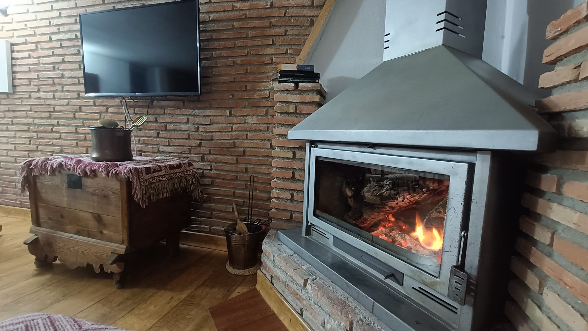 Salón Casa Bodeguilla Chimenea encendida en Casa Bodeguilla con televisión