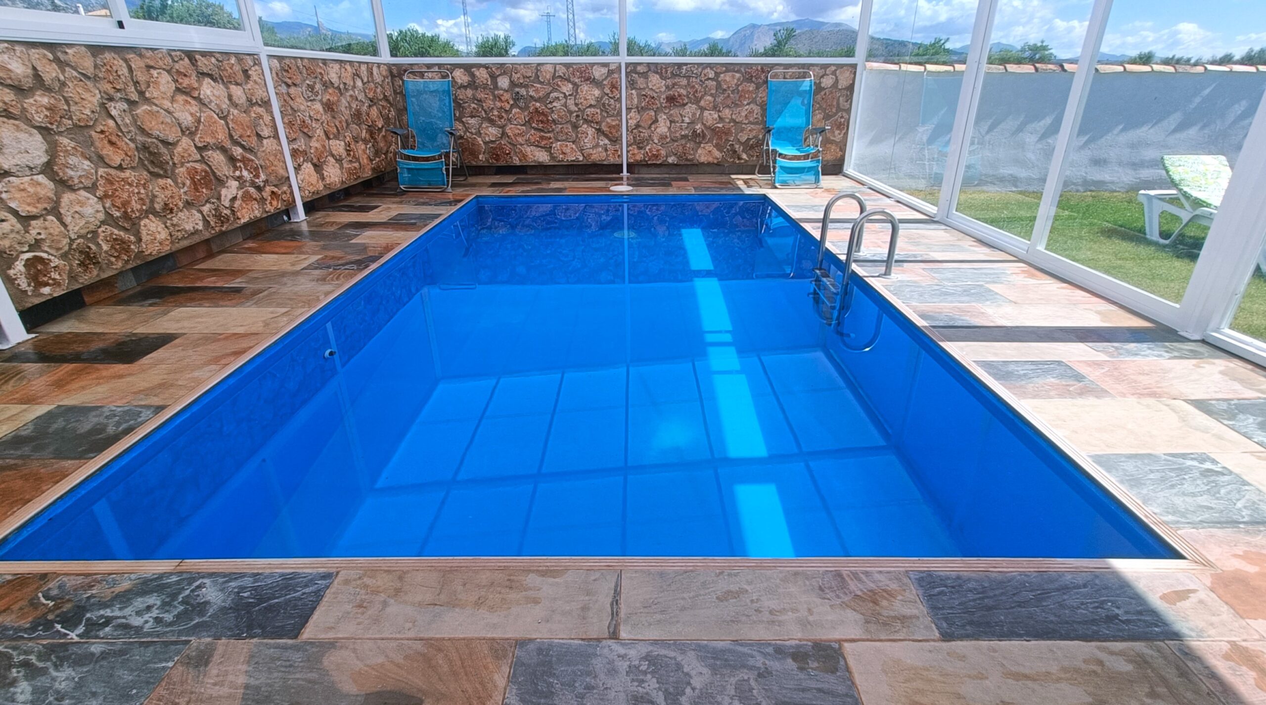 Zona de piscina con sillas sol y sombra Casa Almendros